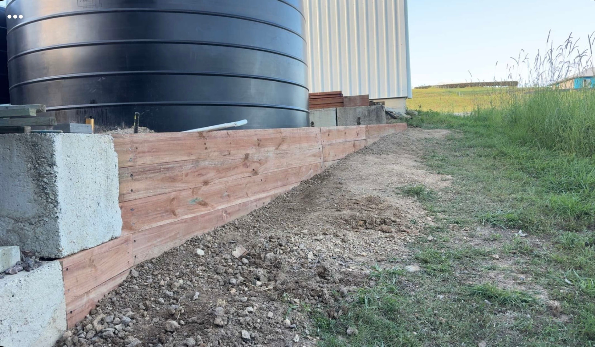 Timber retaining wall built beside a shed and black water tank at Chatsworth QLD