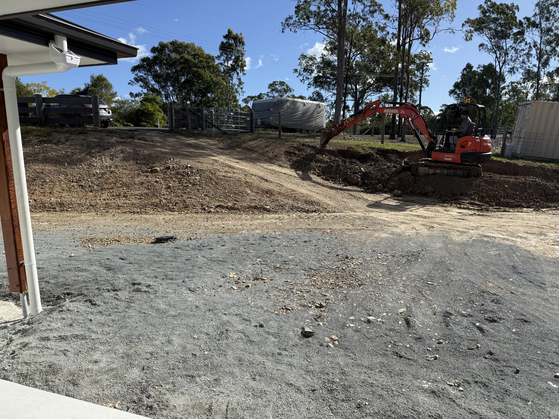 Gravel driveway crossover with culvert pipes and new steel gates near Gympie QLD
