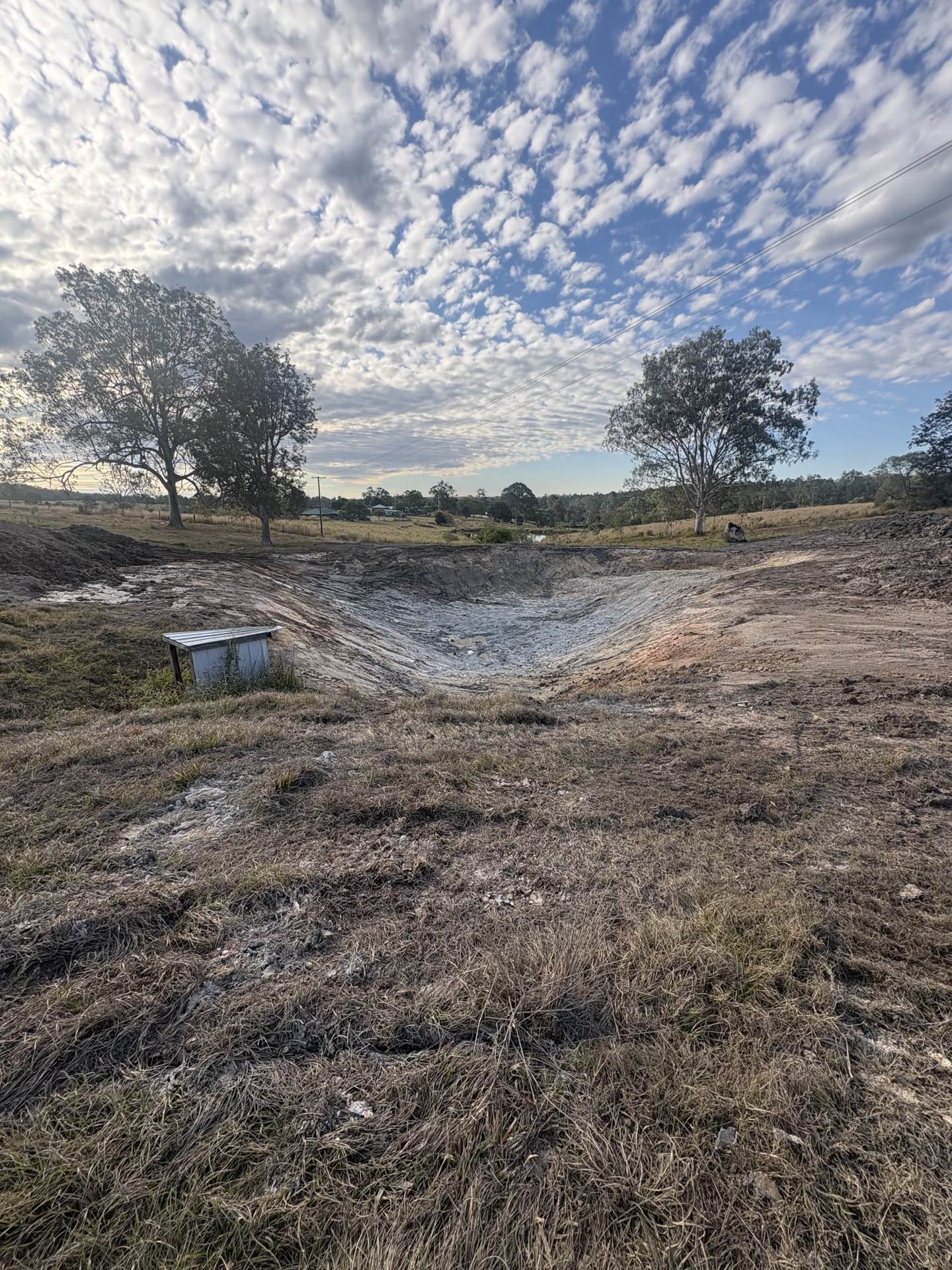 Newly built farm dam holding water with freshly shaped batters at Corella QLD