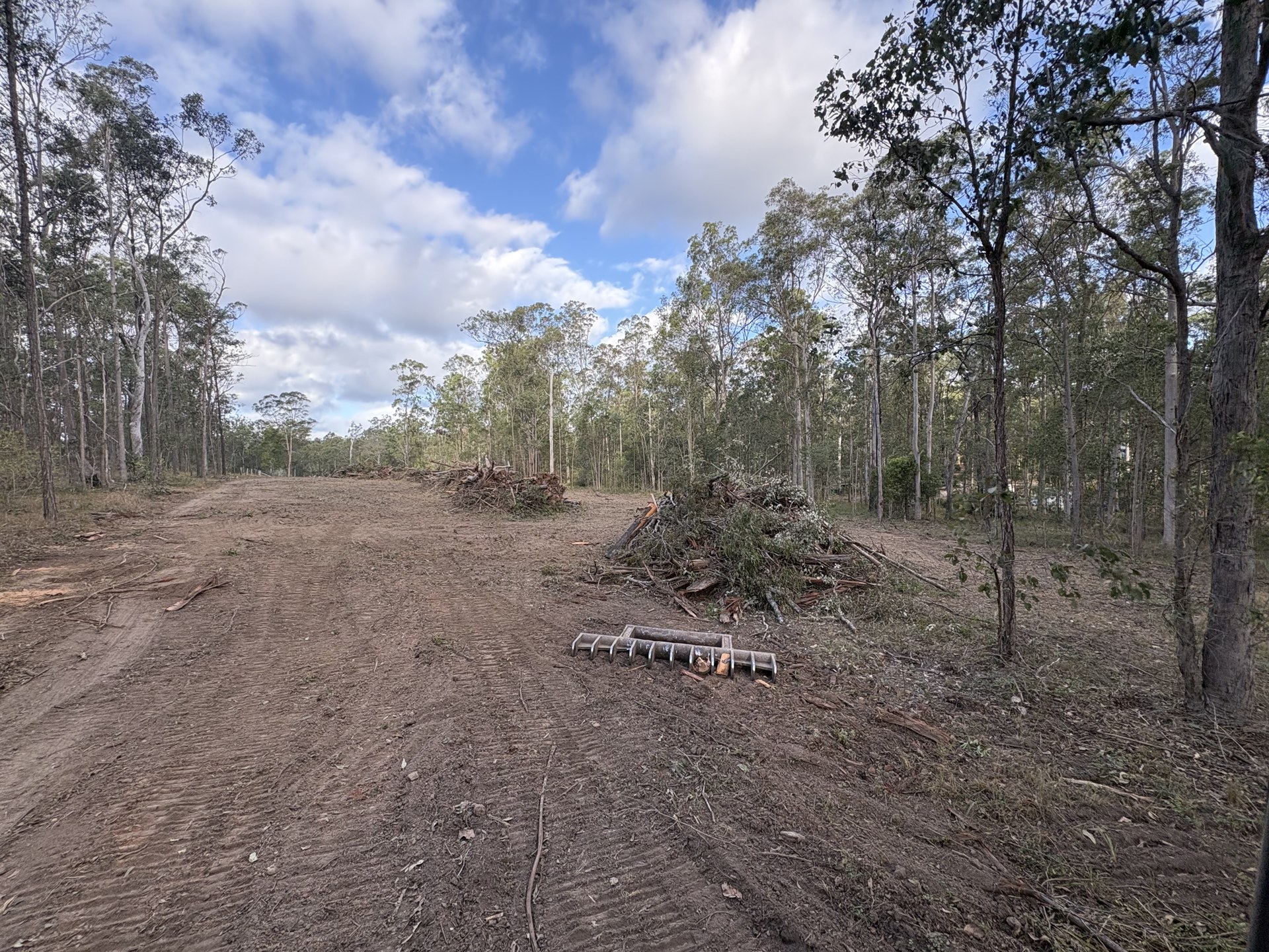 Cleared open ground with timber stacked and mulch raked after clearing at Glenwood QLD