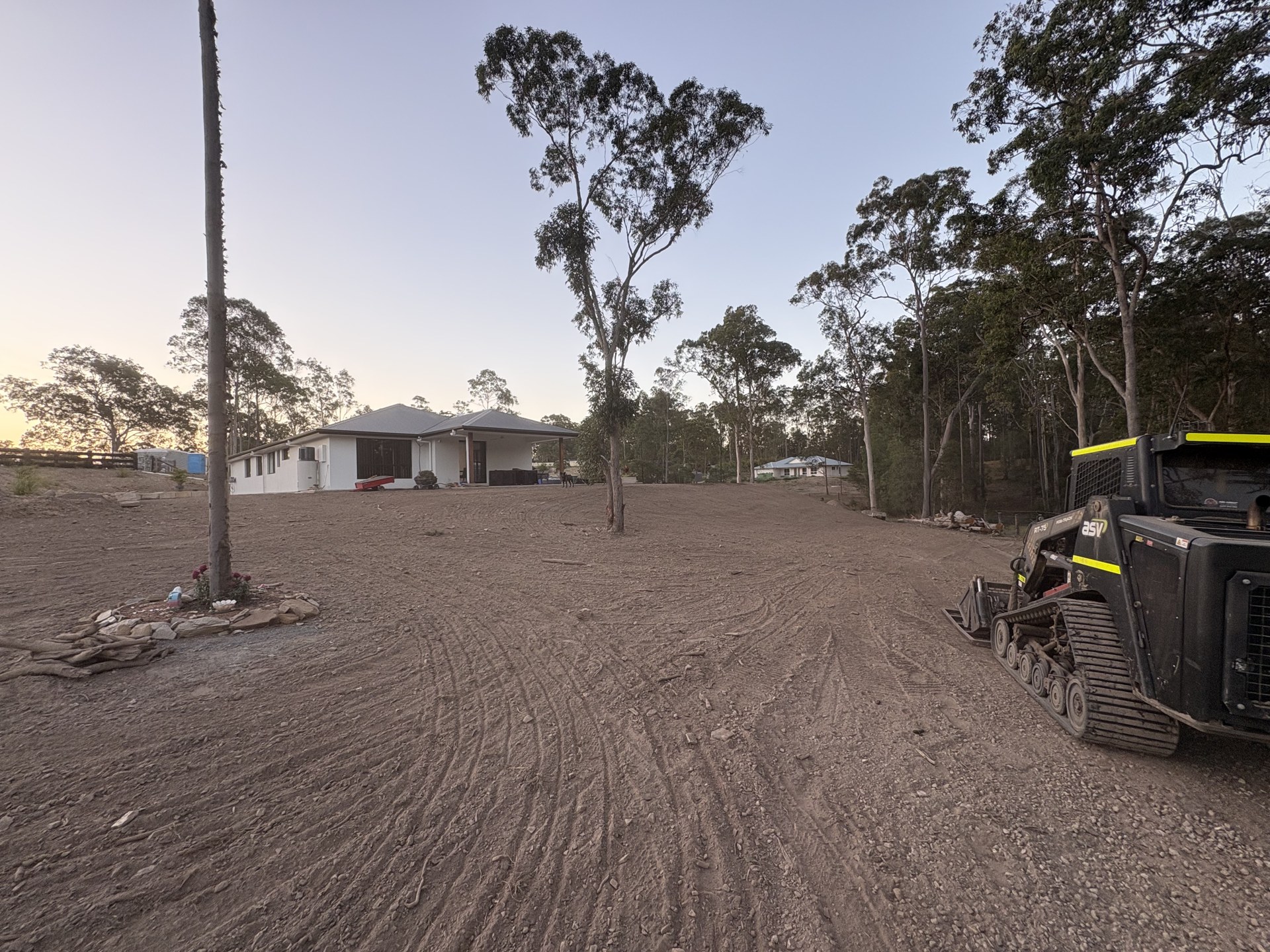 Graded yard with topsoil spread around a rural home at dusk near Gympie QLD