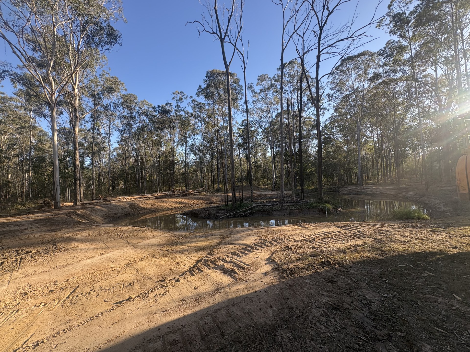 Repaired dam with rebuilt wall, shaped batters and clean water line at Curra QLD