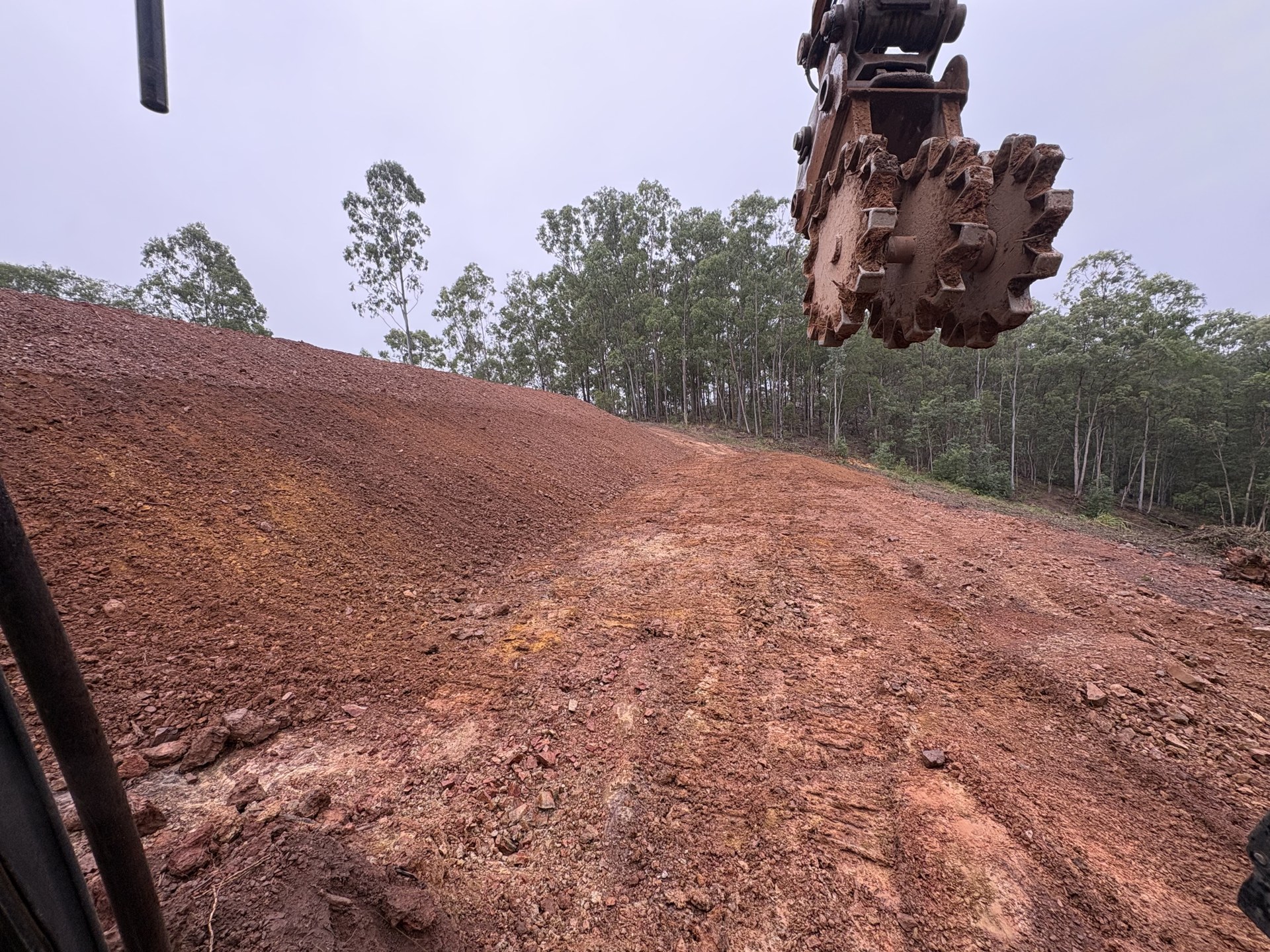 Excavator stripping topsoil and benching ground on a rural block at Glastonbury QLD